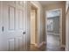 Hallway leading to a bedroom, with a white closet door and wood-look tile floor at 3298 Covered Bridge W Dr, Dunedin, FL 34698