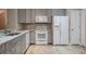 Bright eat-in kitchen with granite countertops, stainless sink, and gray cabinetry at 3298 Covered Bridge W Dr, Dunedin, FL 34698