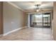 Bright living area with tile floors, fan, access to the outdoor screened lanai at 3298 Covered Bridge W Dr, Dunedin, FL 34698