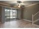 Open living room with tile floors, ceiling fan, and sliding door access to lanai at 3298 Covered Bridge W Dr, Dunedin, FL 34698