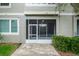 A screened in porch with tile flooring and green bushes at 3298 Covered Bridge W Dr, Dunedin, FL 34698