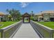 A scenic walking bridge surrounded by lush greenery and well-manicured lawns at 3298 Covered Bridge W Dr, Dunedin, FL 34698