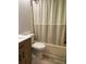 Bathroom with tub and shower combination with cream colored shower curtain and wood vanity at 3610 54Th W St # B8, Bradenton, FL 34209