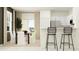 Well-lit dining area flowing into a white kitchen, featuring a dining table with chairs and a bar with stools at 36100 Risa Michele St, Zephyrhills, FL 33541