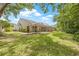 Home exterior featuring a spacious backyard with a screened patio at 3810 Darston St, Palm Harbor, FL 34685