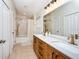 Bright bathroom featuring a dual sink vanity, large mirror, and shower-tub combo at 7001 Interbay Blvd # 121, Tampa, FL 33616