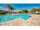 Community pool with clear blue water, lounge chairs, and lush tropical landscaping at 7001 Interbay Blvd # 121, Tampa, FL 33616