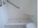 Close up of the bright bathroom shower showcasing the hexagonal floor tiles and grab bar at 840 Virginia St # 301, Dunedin, FL 34698