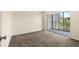 Bedroom with plush carpet, and glass sliding door to covered porch at 840 Virginia St # 301, Dunedin, FL 34698
