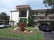 Exterior view of a multi-story condo building featuring carports and landscaped grounds at 840 Virginia St # 301, Dunedin, FL 34698