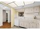 White kitchen, with view of living room, featuring laminate countertops at 840 Virginia St # 301, Dunedin, FL 34698