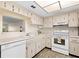The kitchen has a view to the living room and white appliances at 840 Virginia St # 301, Dunedin, FL 34698