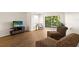 Well-lit living room featuring a balcony, laminate wood flooring and neutral wall paint at 840 Virginia St # 301, Dunedin, FL 34698