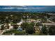 Wide aerial shot showcasing a neighborhood with mature trees near commercial buildings and the ocean in the distance at 878 Franklin Cir, Palm Harbor, FL 34683