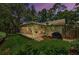 A sunroom addition to the house looks out to a green lawn, garden, and fence at 878 Franklin Cir, Palm Harbor, FL 34683