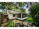 A backyard boasts a screened-in porch, healthy lawn, perimeter fence and mature trees providing ample shade at 878 Franklin Cir, Palm Harbor, FL 34683