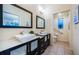 Well-lit bathroom featuring double vanity sinks, modern fixtures, and a view into the shower and toilet areas at 878 Franklin Cir, Palm Harbor, FL 34683
