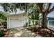 Well-kept one-story home featuring a tidy lawn, two-car garage, and mature trees at 878 Franklin Cir, Palm Harbor, FL 34683