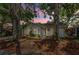 Home exterior with big trees, garden and lights at sunset at 878 Franklin Cir, Palm Harbor, FL 34683