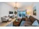 Bright living area featuring a sectional sofa, stylish rug, patio access, and decoratively lit with lamps at 878 Franklin Cir, Palm Harbor, FL 34683