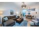 Comfortable living room with a sectional sofa, a wooden coffee table, a blue rug, and a view into the dining area at 878 Franklin Cir, Palm Harbor, FL 34683