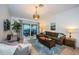 Cozy living room with sectional sofa, tree, and sliding doors leading to an outdoor patio with seating at 878 Franklin Cir, Palm Harbor, FL 34683
