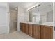 Bright bathroom featuring double vanity with marble countertops and a walk-in shower with glass door at 20115 Nob Oak Ave, Tampa, FL 33647