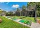 Outdoor batting cage with netting, artificial turf, and lush green grass, perfect for practicing your swing at 20115 Nob Oak Ave, Tampa, FL 33647