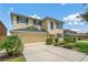 This home features a beautiful lawn, two car garage, and yellow stucco exterior with green shutters at 20115 Nob Oak Ave, Tampa, FL 33647