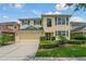 Charming two-story home featuring a manicured lawn, two car garage, and vibrant yellow stucco at 20115 Nob Oak Ave, Tampa, FL 33647