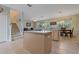 Kitchen island with sink, dining area, and staircase in this open-concept layout at 20115 Nob Oak Ave, Tampa, FL 33647