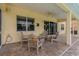 Covered patio with brick pavers, ceiling fan, and comfortable seating offers outdoor relaxation at 20115 Nob Oak Ave, Tampa, FL 33647