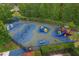 A spacious playground with various play structures and a soft, colorful ground cover, surrounded by a black fence at 20115 Nob Oak Ave, Tampa, FL 33647