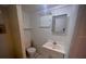 Functional bathroom featuring a sink, mirror, toilet, and a window for natural light at 2101 E Ellicott St, Tampa, FL 33610