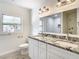 Bright bathroom featuring a double vanity with granite countertop and modern fixtures at 2101 E Ellicott St, Tampa, FL 33610