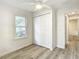 Cozy bedroom with wood-look floors, a window, and bi-fold closet doors at 2101 E Ellicott St, Tampa, FL 33610