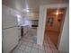 The kitchen features essential appliances, a vintage sink, tile floors, and access to another room at 2101 E Ellicott St, Tampa, FL 33610
