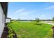 Spacious backyard with lush green grass and a serene lake view at 2743 Winding Creek Trl, North Port, FL 34289