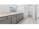 Elegant bathroom boasts double sinks, gray cabinets, tile flooring, and a glass-enclosed shower at 2743 Winding Creek Trl, North Port, FL 34289