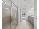 This bathroom offers a luxurious glass shower, tile floors, and a large gray vanity at 2743 Winding Creek Trl, North Port, FL 34289