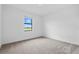Clean bedroom offers a lovely window view and soft carpet for relaxation and rest at 2743 Winding Creek Trl, North Port, FL 34289