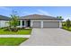 Beautiful single-story home with a gray exterior, a three-car garage, and a brick paver driveway at 2743 Winding Creek Trl, North Port, FL 34289