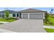 Charming one-story home boasts a 3-car garage and well-manicured landscaping along a brick paver driveway at 2743 Winding Creek Trl, North Port, FL 34289