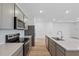 Kitchen with white counters, stainless appliances, gray cabinets, and light wood flooring at 2743 Winding Creek Trl, North Port, FL 34289