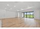 Spacious living area with light wood floors and expansive sliding glass doors to the outside at 2743 Winding Creek Trl, North Port, FL 34289
