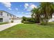 Attractive single-story home with a two-car garage, tropical landscaping, and a well-manicured front lawn at 3921 E Eden Roc Cir, Tampa, FL 33634
