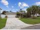 Charming single-story home with a two-car garage, lush landscaping, and a cracked driveway in a sunny neighborhood at 3921 E Eden Roc Cir, Tampa, FL 33634