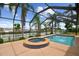 A screened in pool area featuring a spa. The area is perfect for relaxation and outdoor entertaining at 3921 E Eden Roc Cir, Tampa, FL 33634