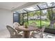 Screened porch with an outdoor table and seating that overlooks the lush green lawn at 4104 Northmeadow Cir # 4104, Tampa, FL 33618