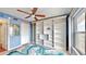 Bright bedroom with a modern ceiling fan, a large built-in bookshelf, and a colorful accent rug at 4900 Brittany S Dr # 1011, St Petersburg, FL 33715
